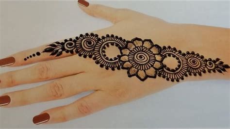 a woman's hand with henna tattoos on it