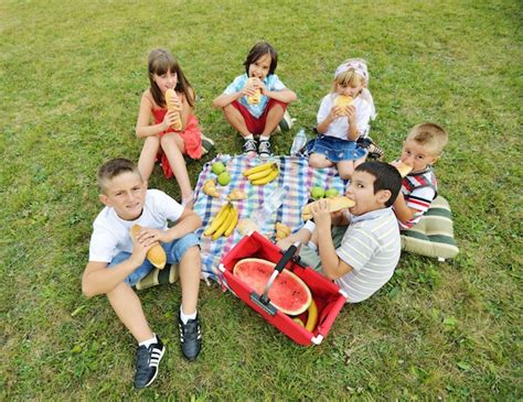 Premium Photo | Children having picnic on meadow in circle