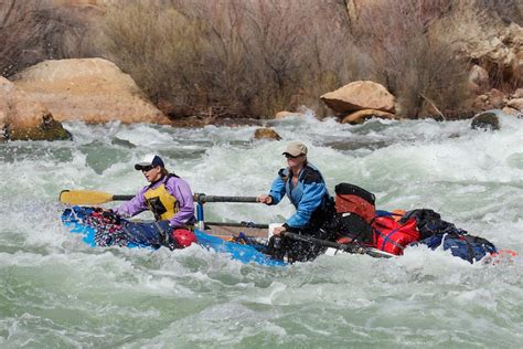 two people in a kayak paddling through rapids