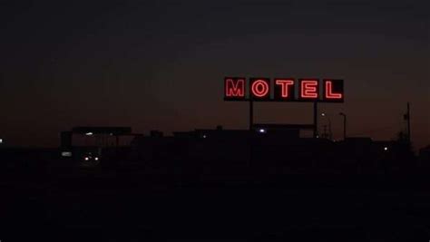 Long shot of motel neon sign flickering at night - Stock Video Footage - Dissolve