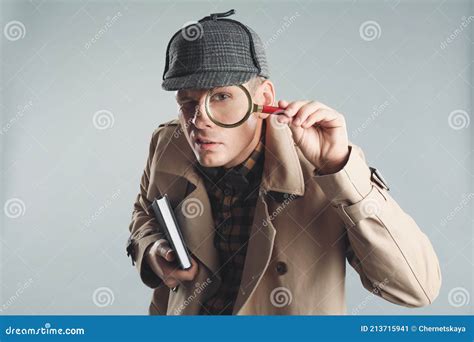 Male Detective Looking through Magnifying Glass on Grey Background Stock Image - Image of ...