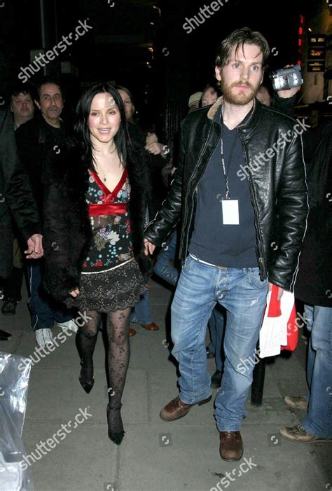 Man and Woman Walking Down the Street at Night