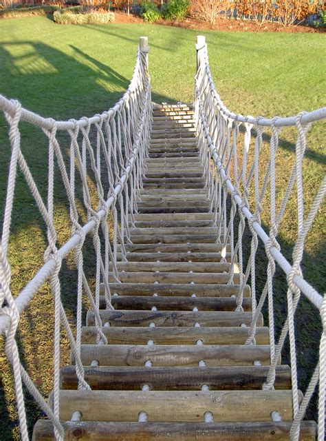 A Rope Bridge entrance from the lawn into the treehouse, using round timber logs and 'soft-to ...