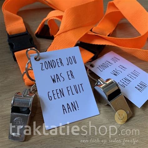 two orange lanyards with tags attached to them on a wooden table next to a sign