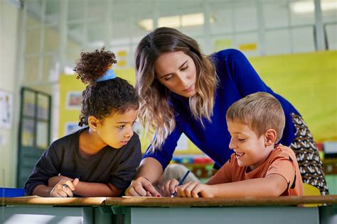 "Teacher Helping Her Young Pupils In A Class Activity" by Stocksy Contributor "ALTO IMAGES ...