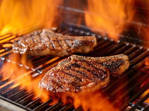 Two Ribeye Steaks Grilling On The Open Flame Stock Photo - Download Image Now - iStock