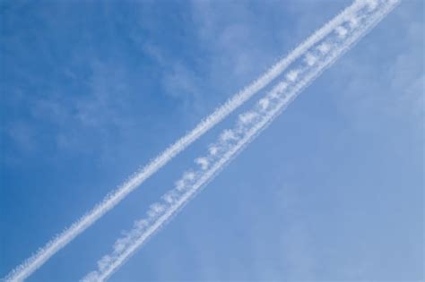 Premium Photo | Airplane trails with cloudy blue sky