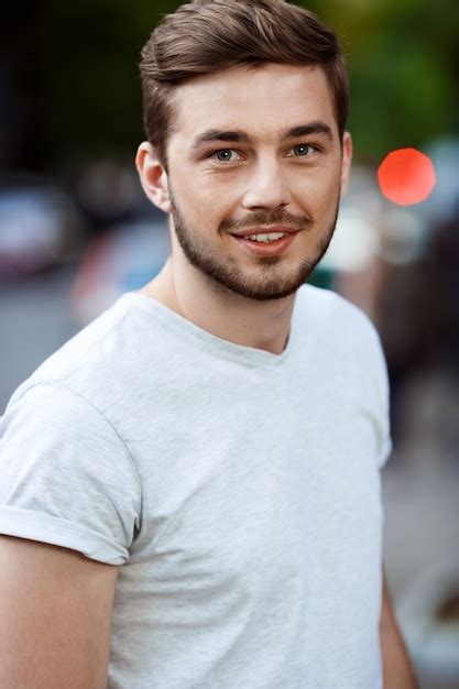 Free Photo | Close up portrait of handsome smiling young man in white t-shirt on blurry outdoor ...