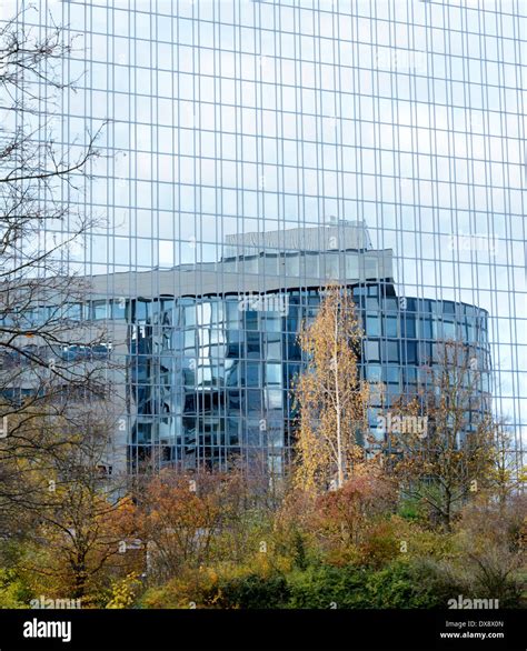 Reflection in the glass facade of a modern office building Stock Photo - Alamy