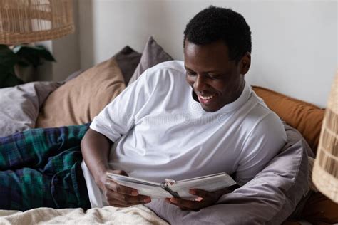 Man Reading a Book on His Bed at Home Stock Photo - Image of peaceful, leisure: 223513520