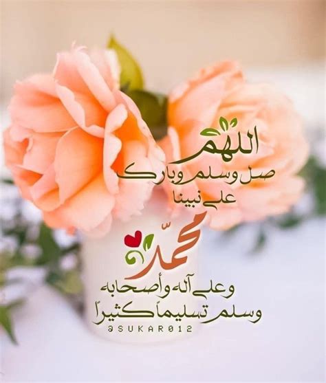 two pink roses in a white vase with arabic writing