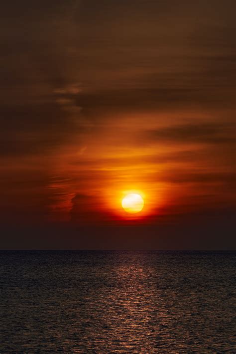 Download wallpaper 3761x5641 sunset, sun, horizon, glare, sky, water hd background