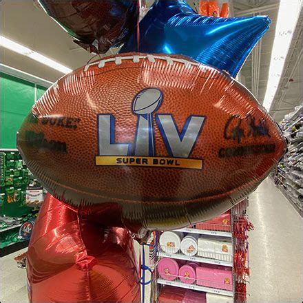 an inflatable football sitting on top of a shelf next to balloons and other items