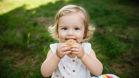 Premium Photo | Happy toddler eating cookie