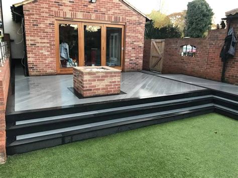 an outdoor deck with steps leading up to the back door and brick ...