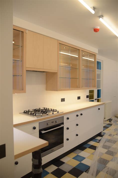 Kitchen - Beech wall units with glass sliding doors. White laminated work top with beech edge ...