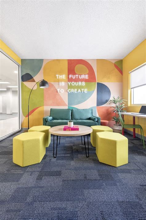 an office lobby with colorful furniture and large wall mural behind the couch is a round coffee ...