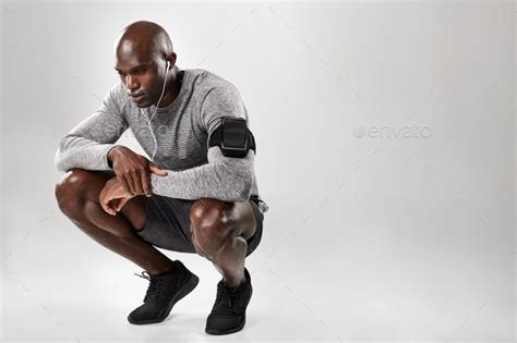 African male model crouching on grey background | Man kneeling, Gray ...