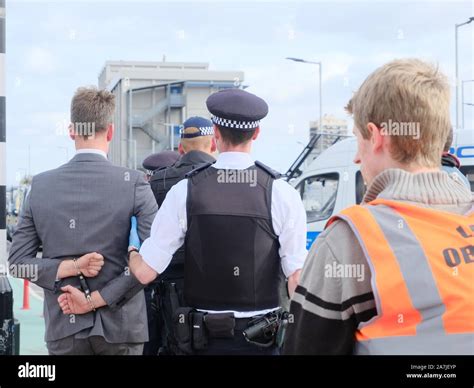 Extinction Rebellion protester is led away by police after being arrested inside City Airport on ...