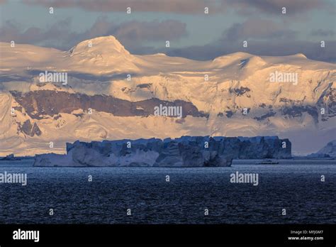 Sunrise, with atmospheric cloud and mist, mountains, glaciers and icebergs, Andvord Bay, Graham ...