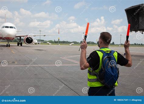 Aviation Marshaller Meets Airplane at the Airport. Airport Worker. Modern Airport. Aviation ...