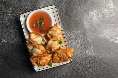 Premium Photo | A plate of fried dumplings with a dipping sauce