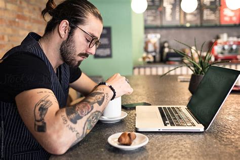 «Trendy Tattooed Man In A Coffee Shop With Laptop.» del colaborador de ...