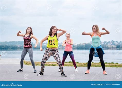 A Group of Young Women, Wearing Colorful Sports Outfits, Doing Zumba ...