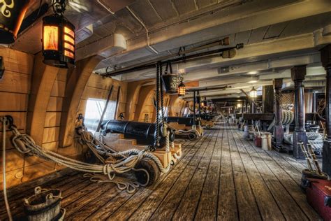 the inside of a boat with lots of wooden flooring and ropes on each side