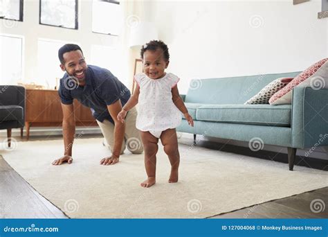 Father Encouraging Baby Daughter To Take First Steps At Home Royalty-Free Stock Image ...