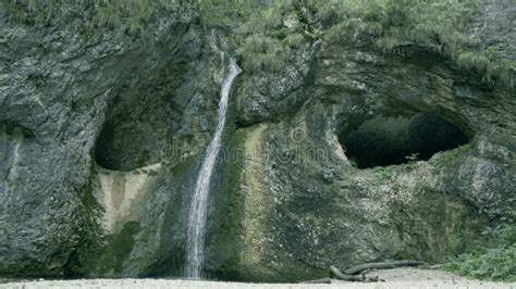 Waterfall and Cave Entrances in a Mountain Area Stock Image - Image of ...