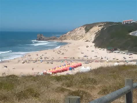 the beach is crowded with people and umbrellas