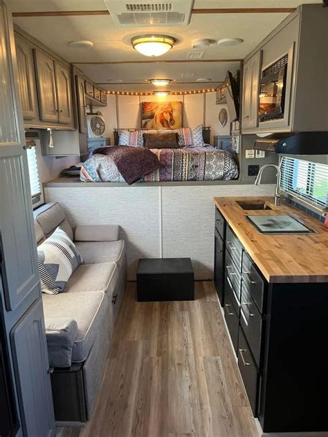 the interior of an rv with a kitchen and living room in it, as well as a bed