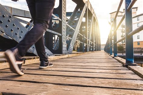 Premium Photo | Man walking over a bridge at sunset