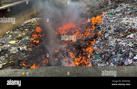 Fire burning trash heap, pouring water to extinguish - environment ...