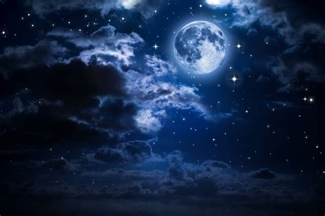 the full moon is shining brightly in the night sky with clouds and stars around it