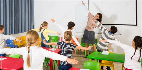 Teacher conducting warm-up with pupils Stock Photo | Adobe Stock