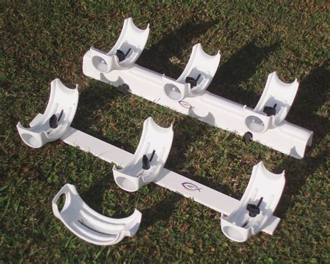 four white plastic brackets sitting on top of the grass in front of each other,