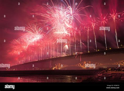 Group of people watching fireworks over Forth road bridge, Edinburgh ...