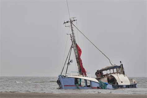 Free Photo | Sinking abandoned ship at the seashore under the clear sky