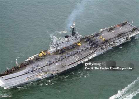 An aerial view of the aircraft carrier HMS Hermes, its deck lined by ...