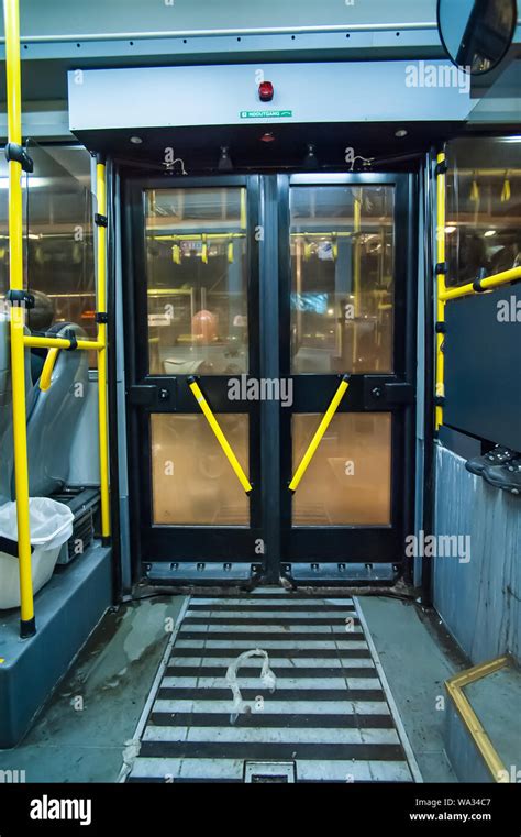 A bus door with yellow handles seen from the inside Stock Photo - Alamy