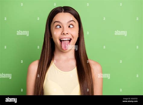 Portrait of excited carefree person squint eyes tongue out have fun isolated on green color ...