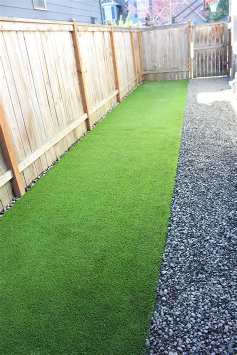 a backyard with grass and gravel in the middle