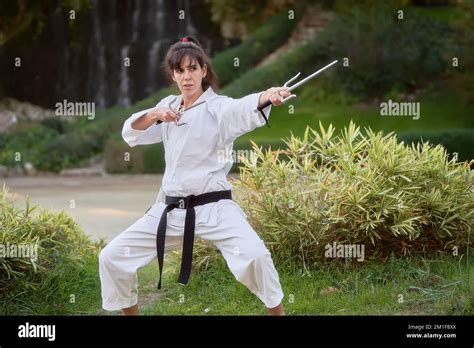 Young karate woman in fighting stance holding a pair of sai outdoors. High quality photo Stock ...