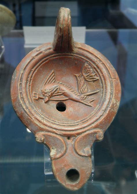 Terracotta oil lamp depicting a dolphin carrying a trident… | Flickr