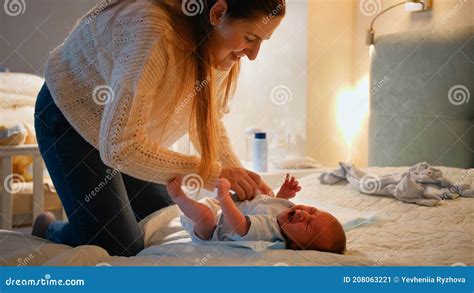 Little Newborn Baby Crying and Screaming while Mother Changing Clothes and Diapers on Bed at ...