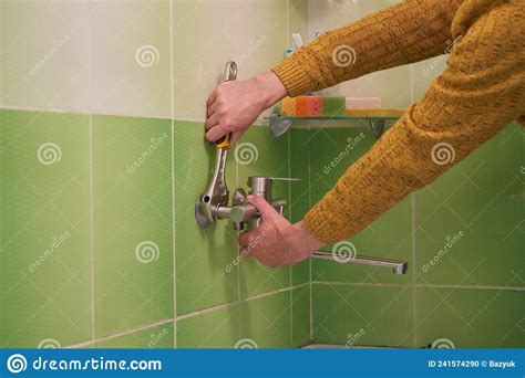 Plumber Installs a Faucet in the Tile,a Man in the Bathroom Installs a New Faucet with an ...