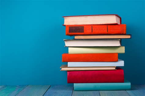 Stack of colorful books, grungy blue background, free copy space - Kristina Günak