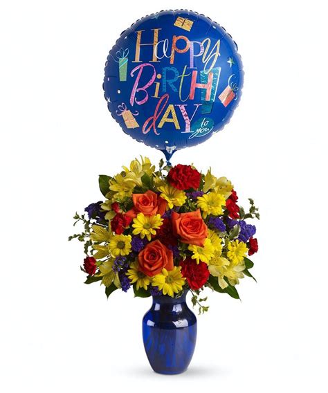 a blue vase filled with yellow and red flowers next to a balloon that ...